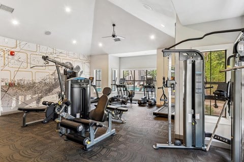A gym with a variety of equipment including a weight bench, a leg press machine, and a cable machine.at Onyx183, Austin, TX  