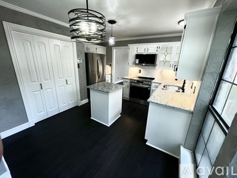 A modern kitchen with white cabinets and a central island.