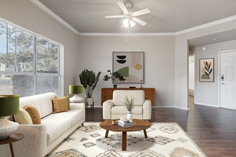 A living room with a white couch, a coffee table, and a rug.