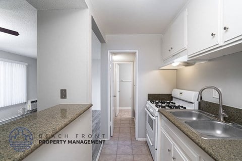 a kitchen with white cabinets and granite counter tops and a sink