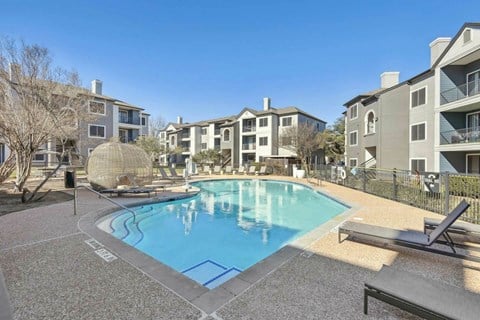 A pool surrounded by apartment buildings and a sun lounger.at Onyx183, Austin  