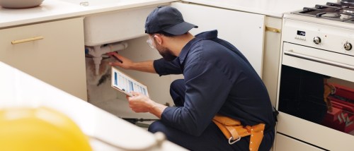 A person using an apartment inspection checklist to document the condition of a rental.