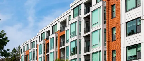 A modern apartment building with balconies and large windows.