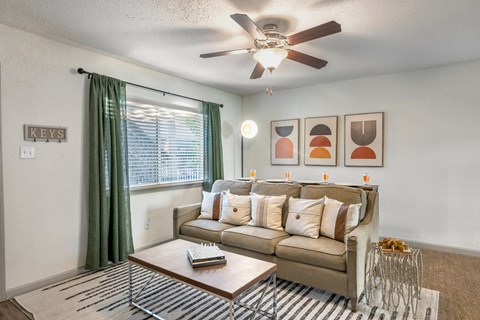 a living room with a couch and a ceiling fan