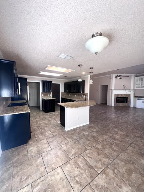 A kitchen with a black refrigerator and a white island.
