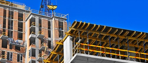 The upper side of a building under construction and part of a crane.