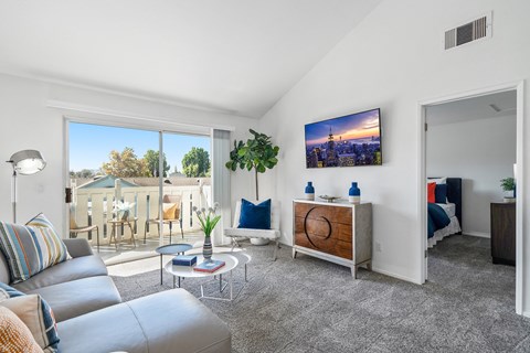 the living room of an apartment with a couch and a tv