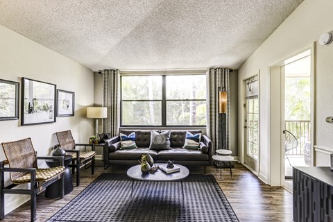a living room with a couch and a table in front of a window