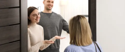 Young couple greeting neighbor who is introducing herself to neighbors, and welcoming her to the building.