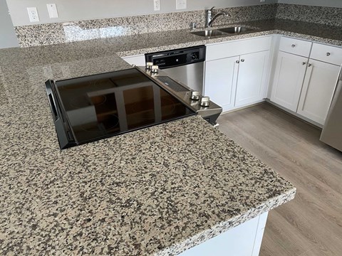 a kitchen with granite counter tops and a stove