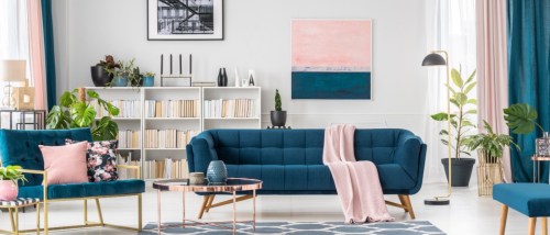 A colorful living room in an upscale apartment with a dark green sofa and armchairs.