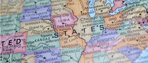 Close-up of a colorful map of the United States, focusing on the Midwest and surrounding regions with detailed city and state names, to be used when moving out of state.
