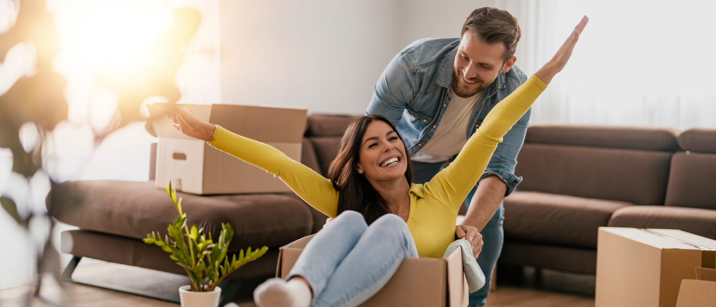 A couple surrounded by boxes while moving in together.