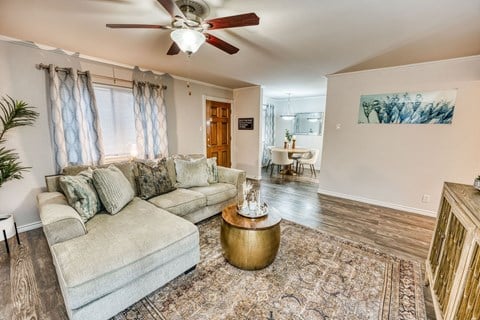 a living room with a couch and a ceiling fan at Juniper Springs Apartments, Austin, TX