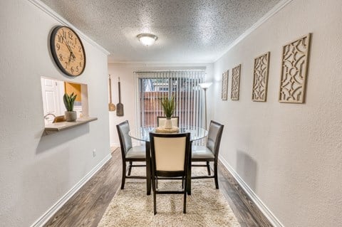 a dining room with a table and chairs and a clock on the wall