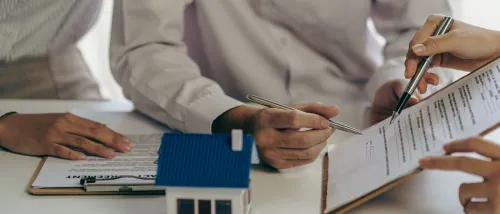 A rental company employee hands over the house key to a customer after thoroughly explaining the terms and conditions of both short-term lease and long-term lease agreements, helping them make an informed decision in the real estate rental process.
