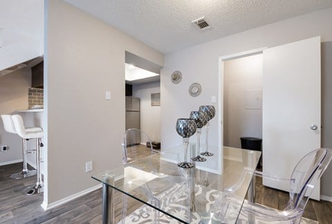 a dining room with a glass table and chairs